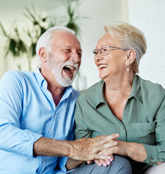 Two women smiling and laughing together outdoors